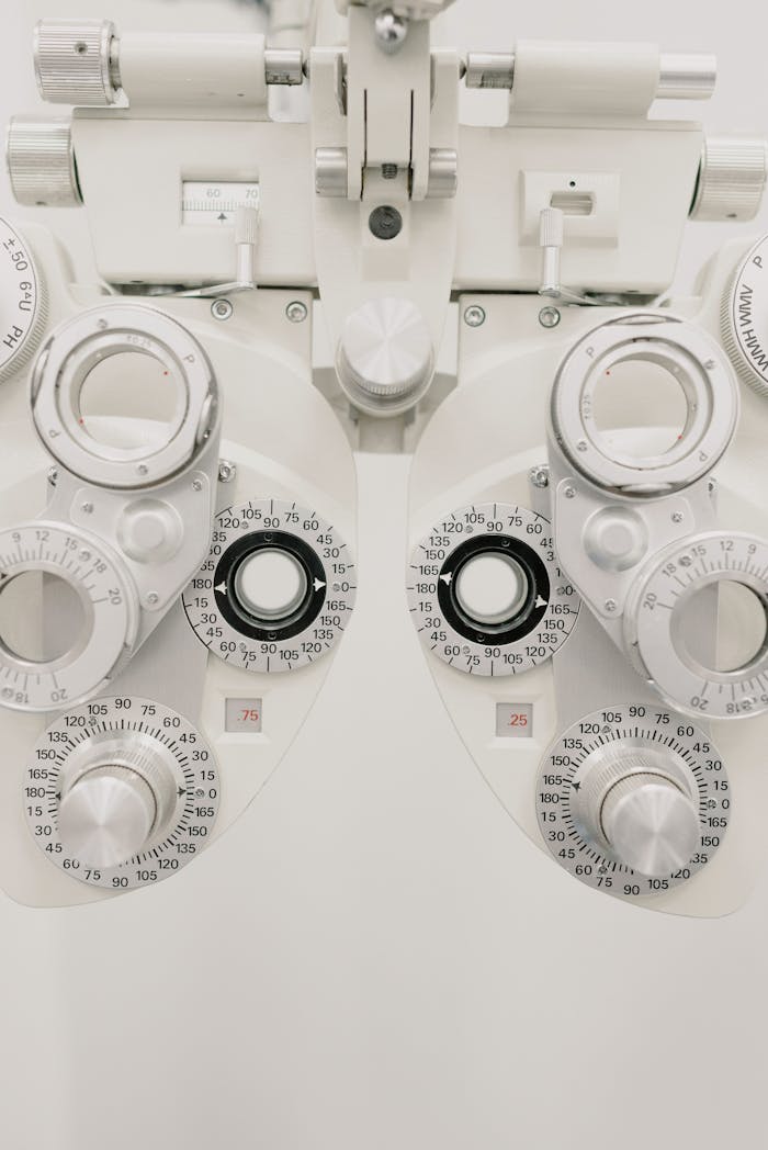 Contemporary medical equipment with ophthalmic glasses for examining vision made of steel placed on white background in modern light clinic